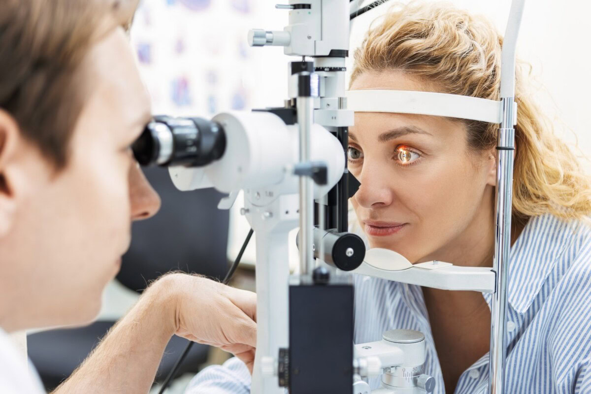 Augenärztin untersucht das Auge einer Patientin an der Spaltlampe.