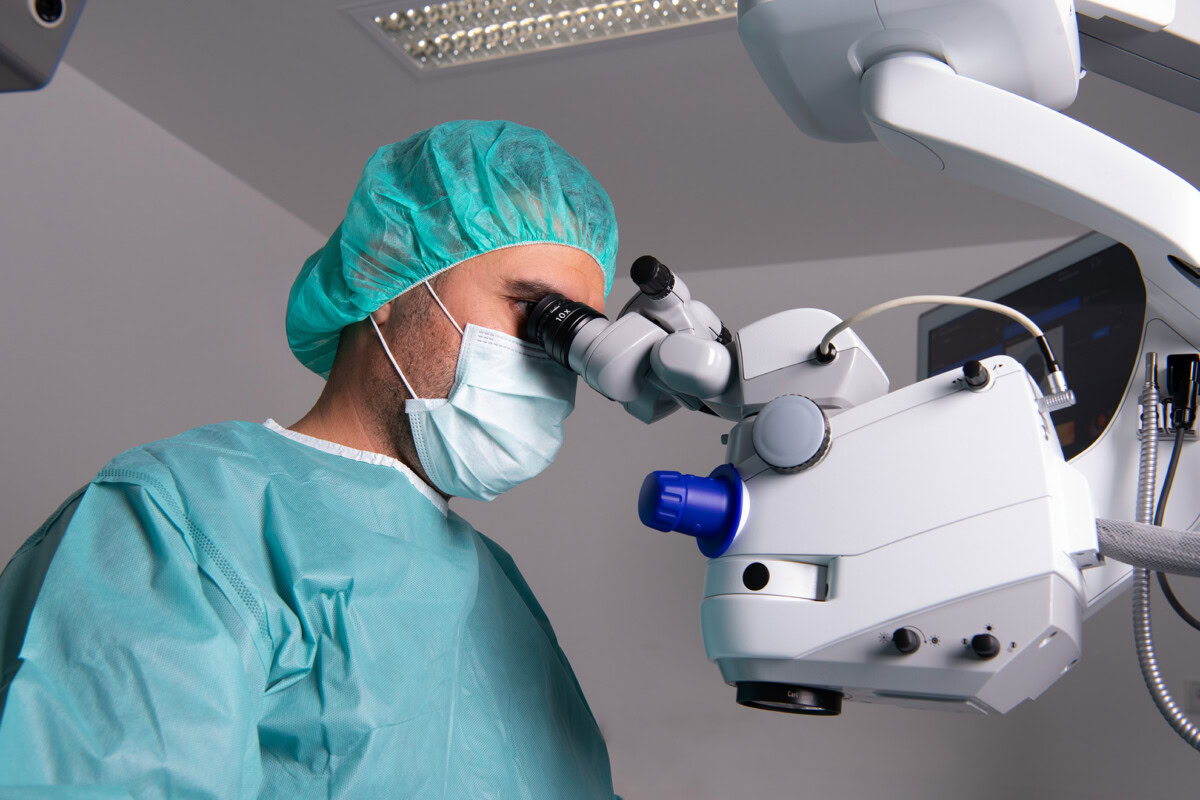 Augenarzt bei Operation mit Mikroskop im OP-Saal.