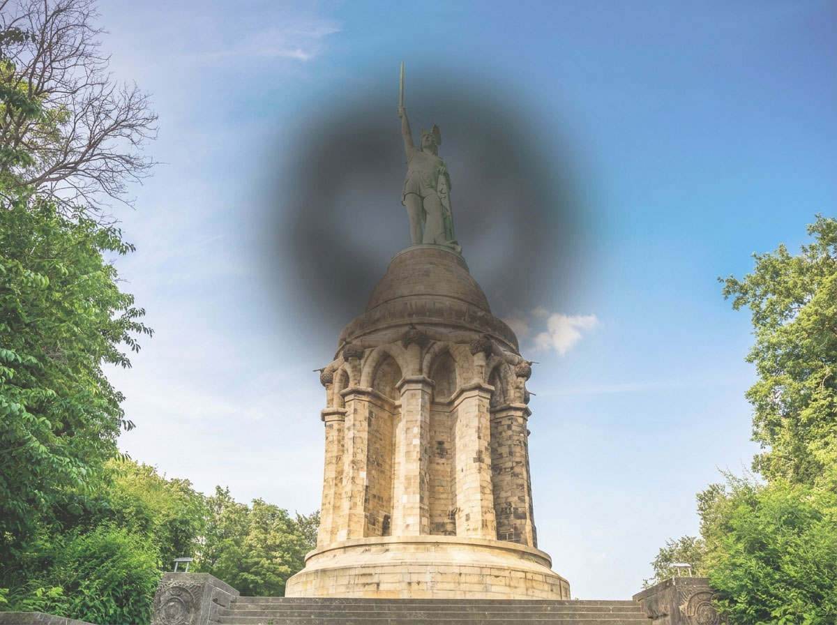 Hermannsdenkmal mit dunklem, verschwommenem Fleck im Zentrum des Sichtfelds – Simulation von Sehstörungen bei Makuladegeneration.